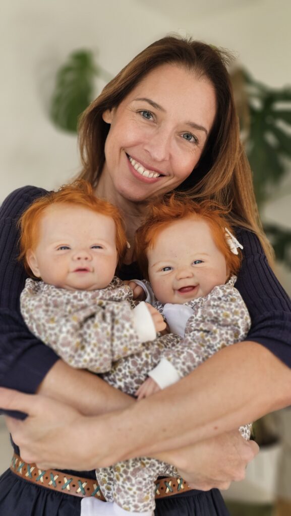 Adeline ginguené portant deux de ses créations poupées reborn